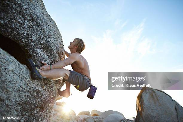 male climber hanging on big rock - rock face fotografías e imágenes de stock