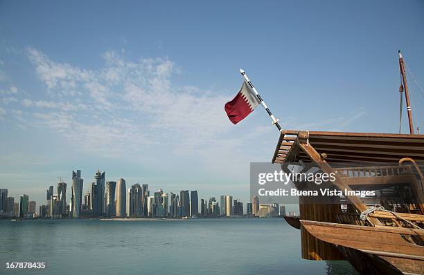traditional boat with qatar's flag and doha skylin - qatar stock pictures, royalty-free photos & images
