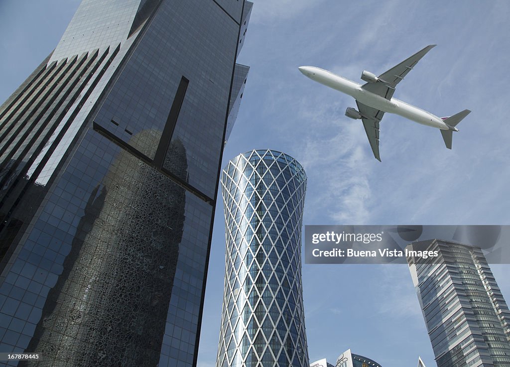 Commercial jet flying over skyscrapers