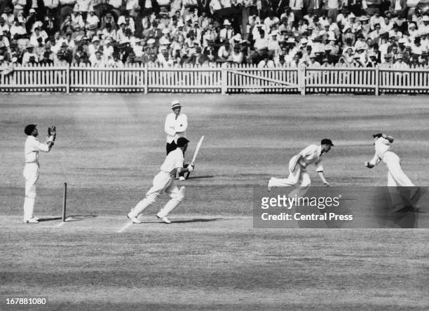 England batsman Joe Hardstaff slips a ball between Australian fielders Ray Lindwall and Colin McCool, during the fourth Ashes Test at Adelaide Oval,...