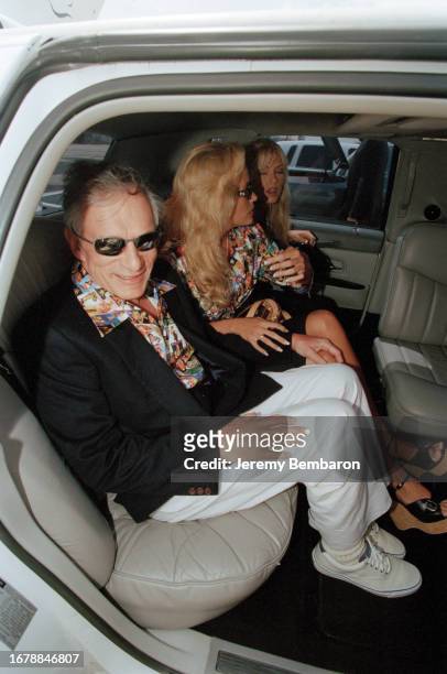 Hugh Hefner, the publisher of Playboy magazine, accompanied by his playmates: Brande Roderick and Sandy Bentley, on 17 May 1999 in Paris.