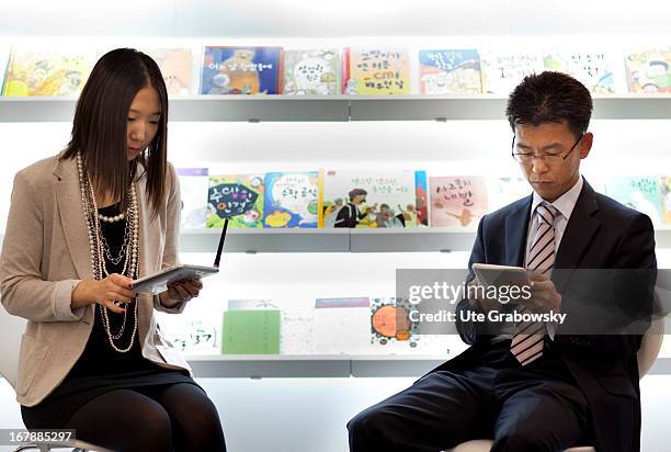 October 07: Female and male reader with Tablet PC at the Book Fair in Frankfurt.