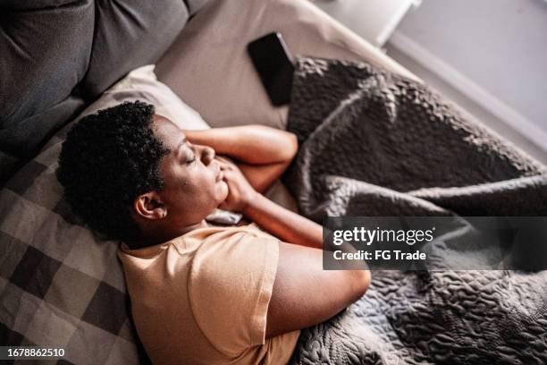 mature woman sleeping in the bedroom at home - woman sleeping stock pictures, royalty-free photos & images