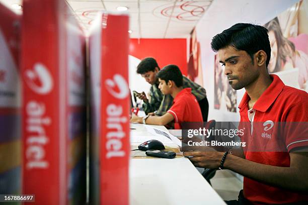 Bharti Airtel Ltd. Sales assistants serve customers at the company's flagship store in Mumbai, India on Thursday, May 2, 2013. Bharti Airtel Ltd.,...