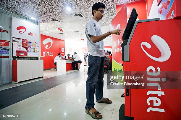 Customer uses a Bharti Airtel Ltd. Automated teller machine at the company's flagship store in Mumbai, India on Thursday, May 2, 2013. Bharti Airtel,...