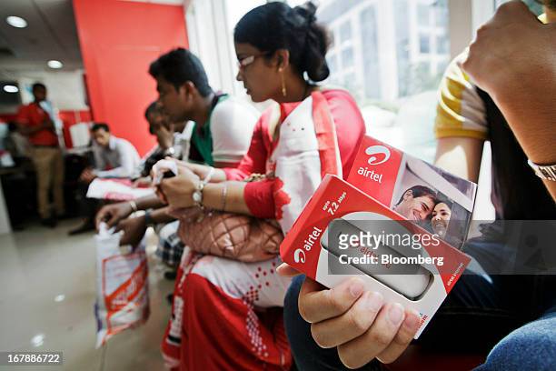 Customer holds a Bharti Airtel Ltd. 3G USB Modem 7.2 Mbps at the company's flagship store in Mumbai, India on Thursday, May 2, 2013. Bharti Airtel,...