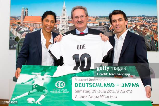 Steffi Jones hands over a ticket for a women's international match to Munich's mayor Christian Ude together with Juergen Igelspacher, general manager...