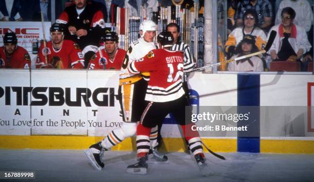 Mario Lemieux of the Pittsburgh Penguins is checked by Brent Sutter of the Chicago Blackhawks during Game 2 of the 1992 Stanley Cup Finals on May 28,...