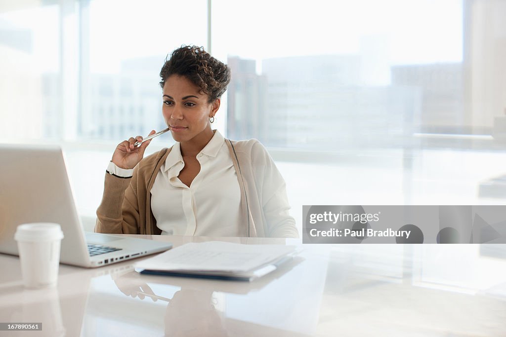Mujer de negocios utilizando el ordenador portátil en oficina