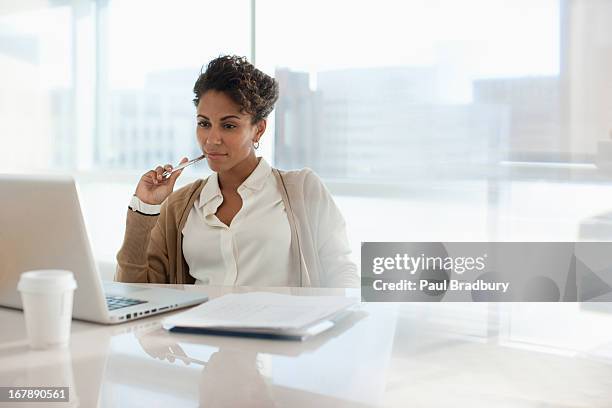 businesswoman using laptop in office - kijken stockfoto's en -beelden