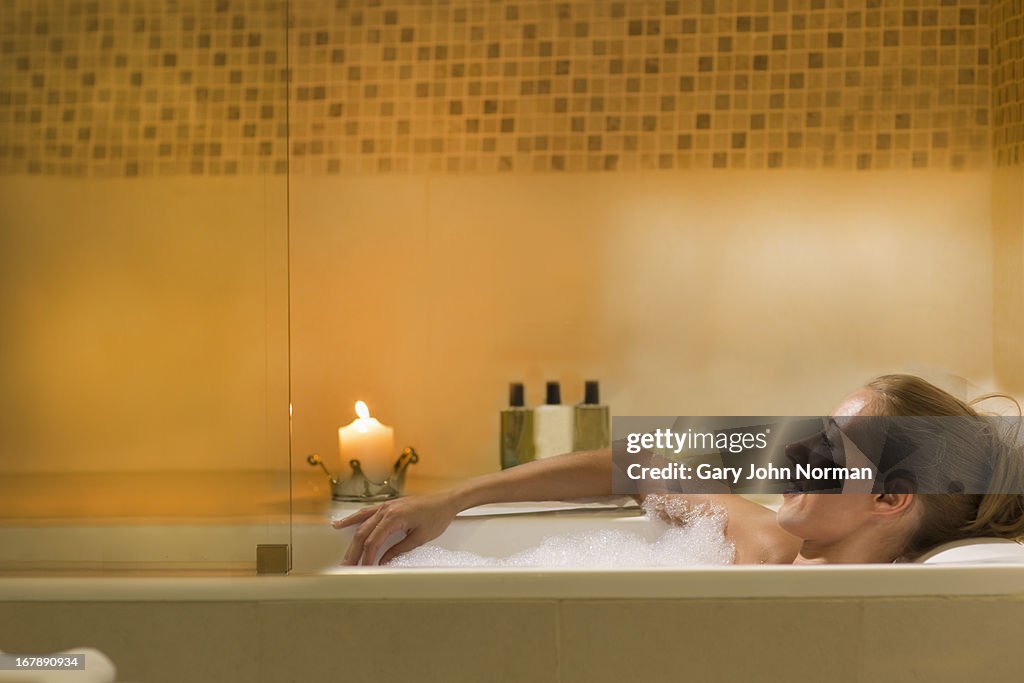 Young woman relaxing in bubbly bath