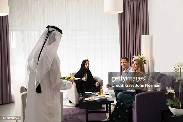 arab couple chatting and sharing food with friends - ghoutra stock pictures, royalty-free photos & images