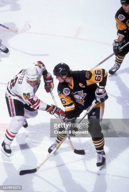 Mario Lemieux of the Pittsburgh Penguins battles with Brent Sutter of the Chicago Blackhawks after the face off during Game 3 of the 1992 Stanley Cup...
