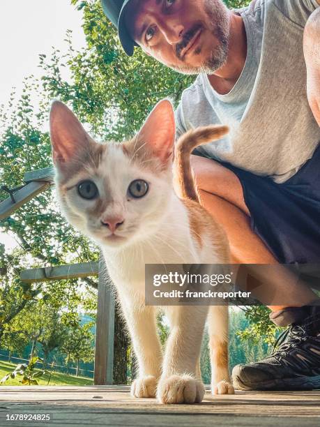 man take a selfie with a white and brown cat - female animal stock pictures, royalty-free photos & images