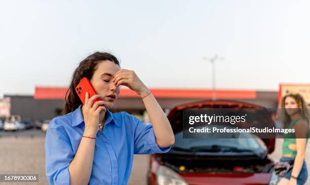 young woman uses mobile phone to seek help after car trouble - engine failure stock pictures, royalty-free photos & images