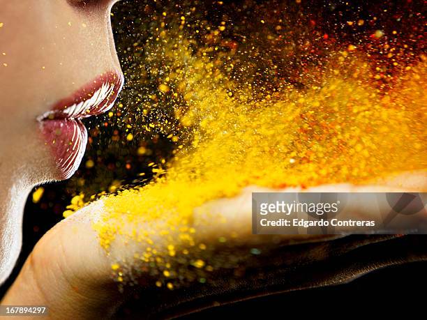 close up of a mouth blowing on yellow dust - blowing dust stock pictures, royalty-free photos & images