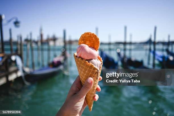 italian gelato in waffle cone in front of san marco canal in venice. - gondola traditional boat stockfoto's en -beelden