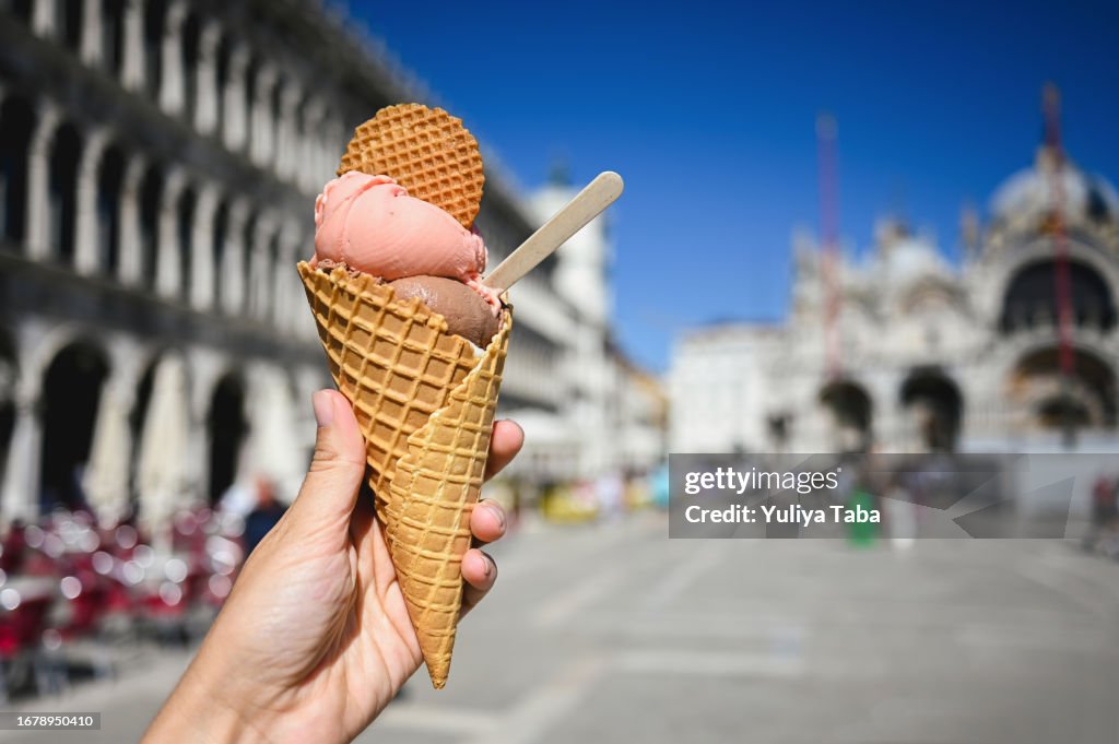 Primo piano della mano della donna che tiene il cono gelato su piazza San Marco a Venezia.
