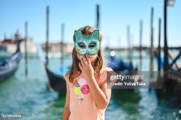 little girl in a carnaval mask in venice in front of grand canal. - mask joke stockfoto's en -beelden