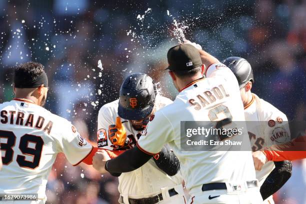 LaMonte Wade Jr. #31 of the San Francisco Giants is congratulated by teammates after he hit a sacrifice fly that scored the winning ru in the 10th...
