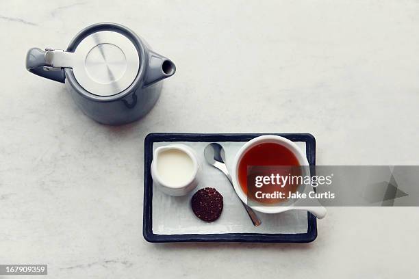 overhead tray of tea, milk and biscuit with teapot - tazza di latte dall'alto foto e immagini stock