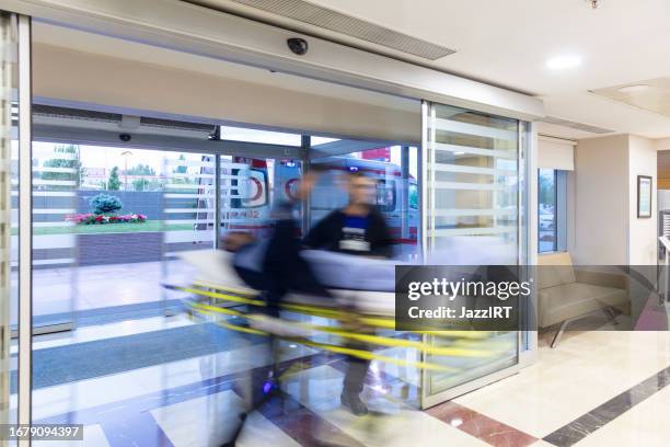 los paramédicos llevan al paciente de la ambulancia al hospital en una camilla. - accidentes y desastres fotografías e imágenes de stock