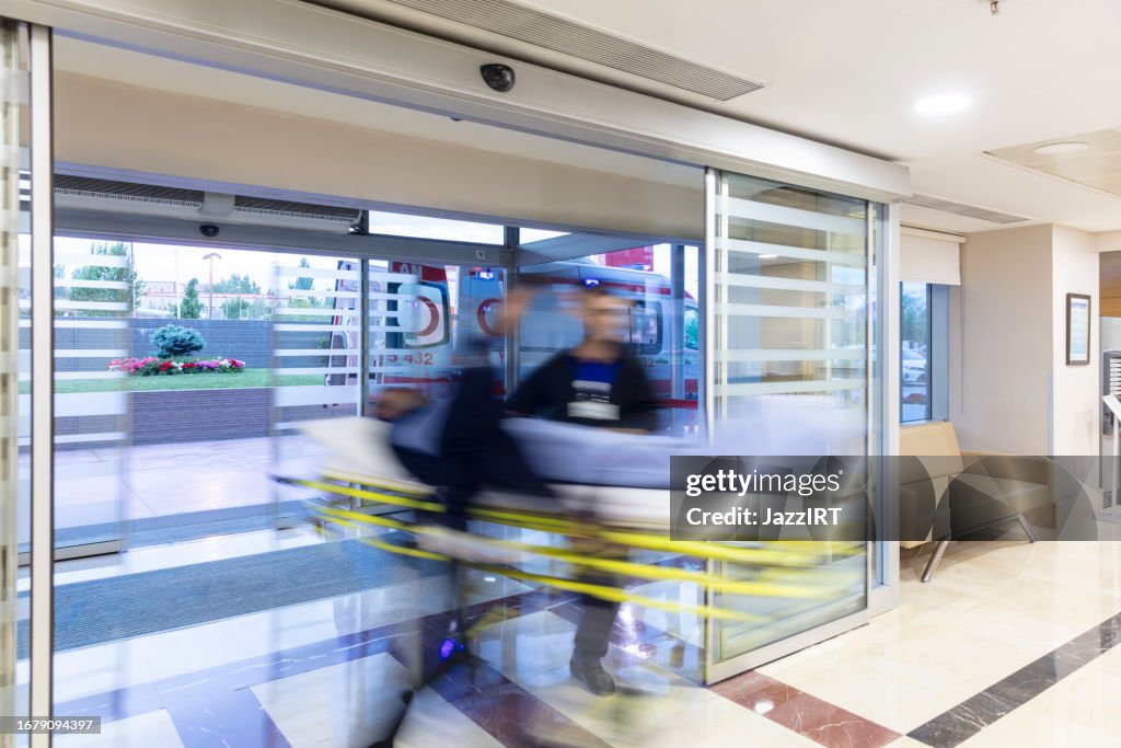 The paramedics take the patient from the ambulance to the hospital on a stretcher.