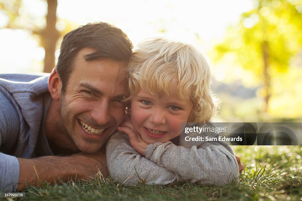 Father and son laying in grass together