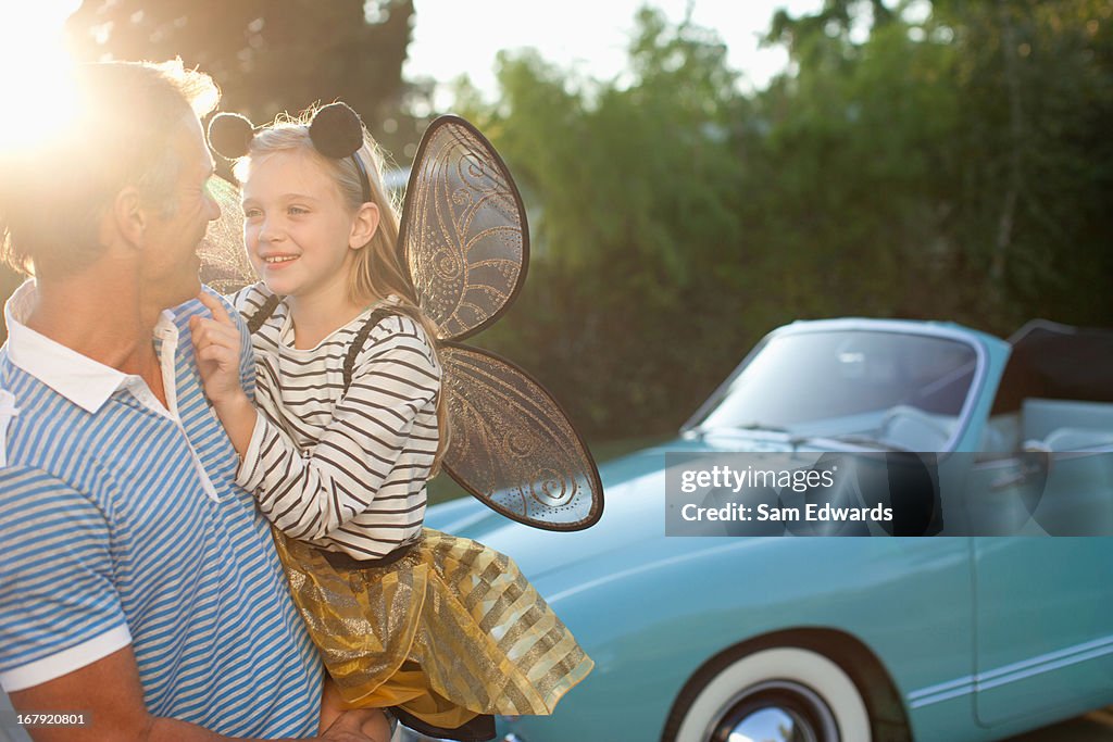 Father holding daughter in fairy wings