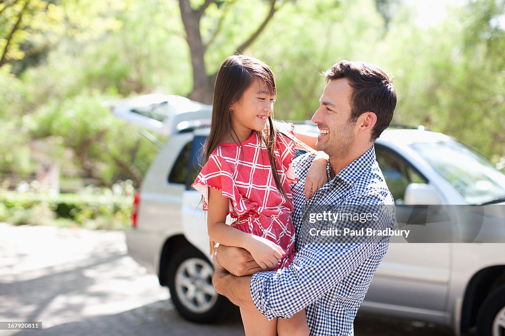 Father holding daughter outdoors