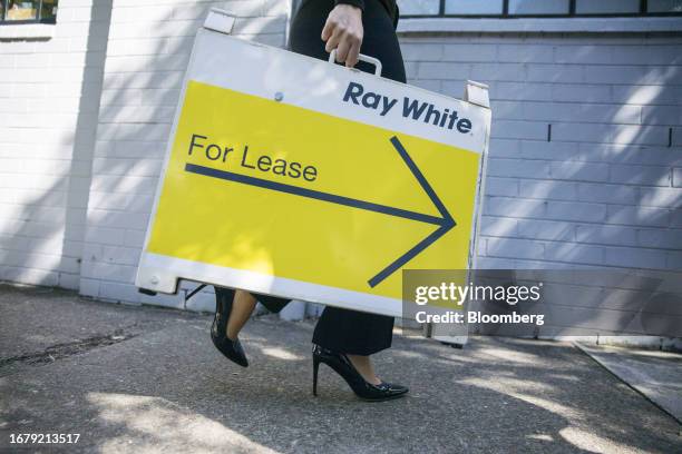 An agent carries a 'For Lease' sign outside a property inspection for potential tenants in Sydney, Australia, on Saturday, August 12, 2023. Less than...