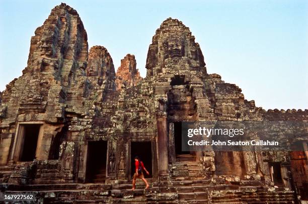 cambodia, the bayon, woman on steps of temple. - bayontempel stockfoto's en -beelden