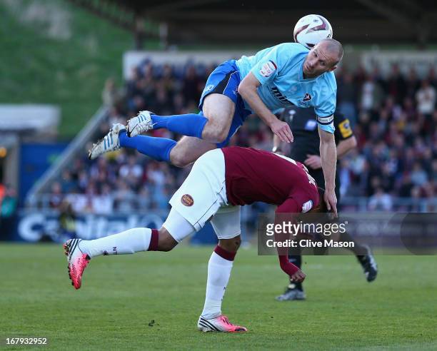 Russell Penn of Cheltenham Town rises above Ishmel Demontagnac of Northampton Town during the npower League Two Play Off Semi Final First Leg match...