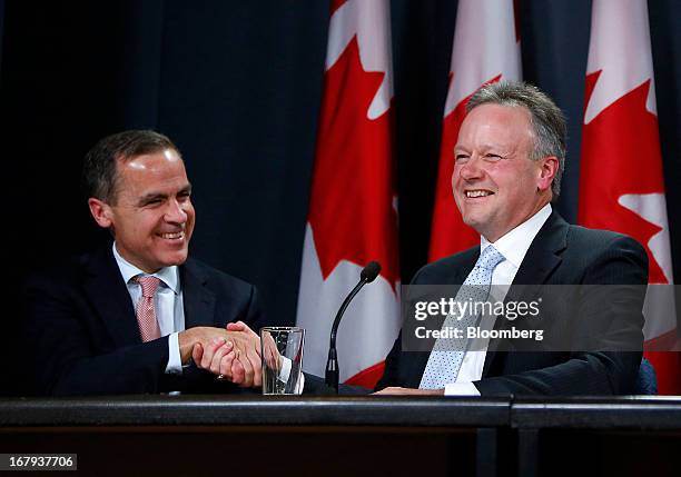 Mark Carney, outgoing governor of the Bank of Canada, left, shakes hands with Stephen Poloz, incoming governor of the Bank of Canada, during a press...