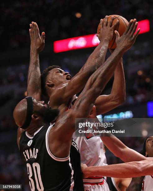 Jimmy Butler of the Chicago Bulls shoots under pressure from Reggie Evans of the Brooklyn Nets in Game Six of the Eastern Conference Quarterfinals...