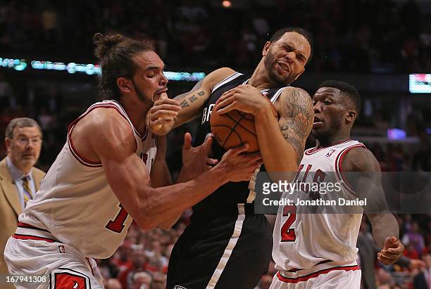 Joakim Noah of the Chicago Bulls forces a jump ball with Deron Williams of the Brooklyn Nets next to Nate Robinson in Game Six of the Eastern...