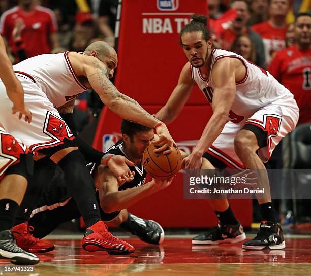 Carlos Boozer and Joakim Noah of the Chicago Bulls strip the ball from Brook Lopez of the Brooklyn Nets in Game Six of the Eastern Conference...
