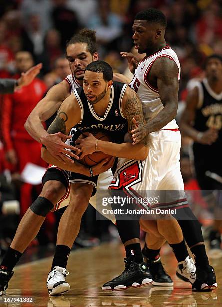 Joakim Noah and Nate Robinson of the Chicago Bulls pressure Deron Williams of the Brooklyn Nets in Game Six of the Eastern Conference Quarterfinals...