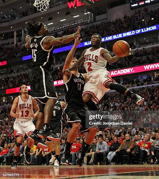 Nate Robinson of the Chicago Bulls leaps to pass against Gerald Wallace and Brook Lopez of the Brooklyn Nets in Game Six of the Eastern Conference...