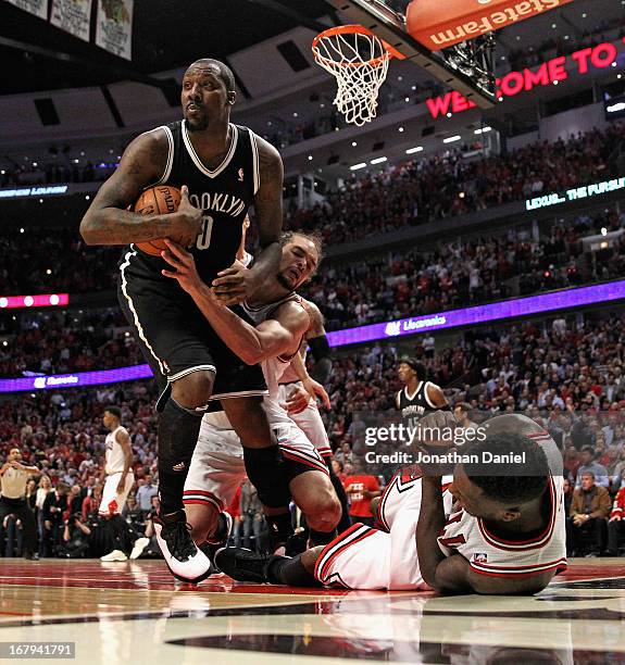 Joakim Noah of the Chicago Bulls grabs Andray Blatche of the Brooklyn Nets as Nate Robinson hits the floor in Game Six of the Eastern Conference...