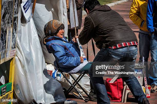 Connie Picciotto, left, who has maintained a protest vigil in front of the White House since the early 1980's, gets photographed by a tourist in...