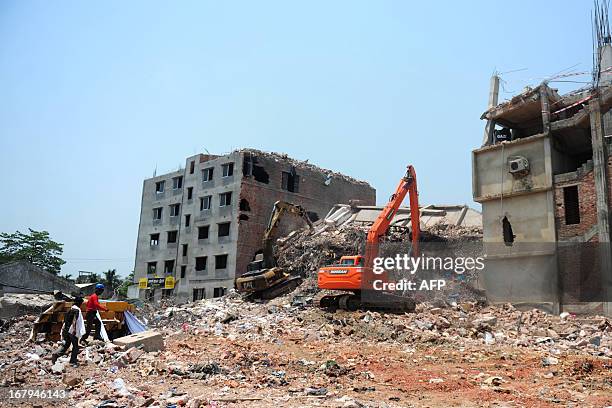 Bangladeshi rescuers use a digger to move debris as Bangladeshi Army personel continue the second phase of a rescue operation using heavy equipment...