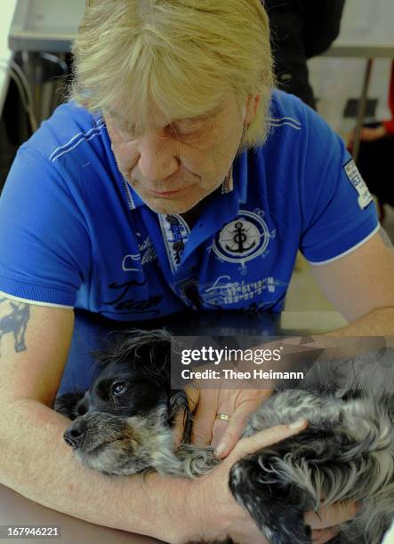 Michael Aurich comforts his cocker spaniel, who is suffering from leukemia, during a meeting with a veterinarian at the Dueppel animal clinic on...