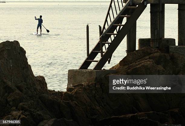 Japanese man enjoys stroud paddle boat during the Golden Week holidays at Shinmaiko beach on May 3, 2013 in Himeji, Japan. Shell collecting are one...