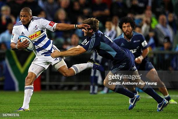 Juan de Jongh of the Stormers beats the tackle from Chris Noakes of the Blues during the round 12 Super Rugby match between the Blues and the...