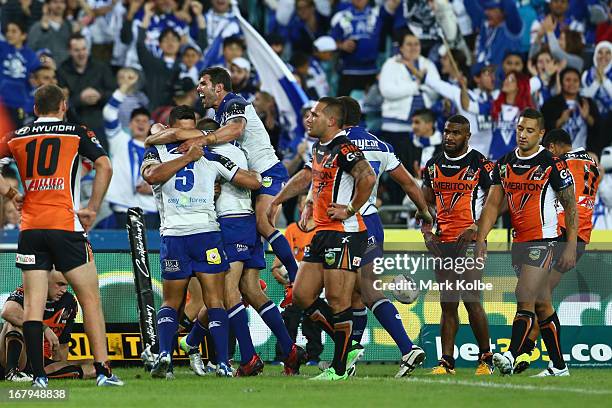 Michael Ennis of the Bulldogs jumps on his team mates as they celebrate with Tim Lafai of the Bulldogs is after he scored a try during the round...