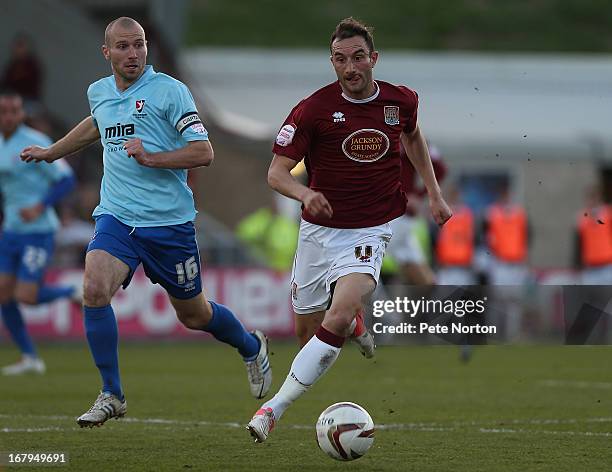 Chris Hackett of Northampton Town moves forward with the ball watched by Russell Penn of Cheltenham Town during the npower League Two Play Off Semi...