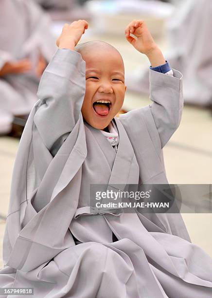 Young South Korean Buddhist boy reacts after have his head shaved during a "children becoming Buddhist monks" ceremony at Chogye Temple in central...