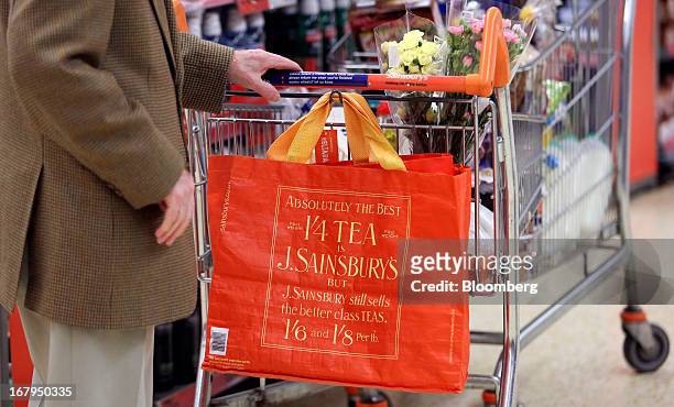 An elderly customer pushes a shopping cart through a Sainsbury's supermarket store, operated by J Sainsbury Plc, in Godalming, U.K., on Thursday, May...