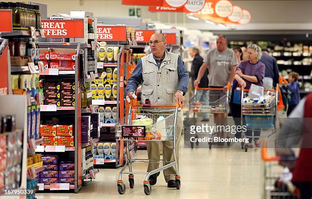 Customers push shopping carts as they look for goods inside a Sainsbury's supermarket store, operated by J Sainsbury Plc, in Godalming, U.K., on...
